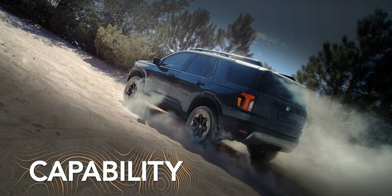 2027 Honda Passport TrailSport Elite in Smoke Blue Pearl back driving up a steep and dusty dirt hill (Mid-Size SUV).
